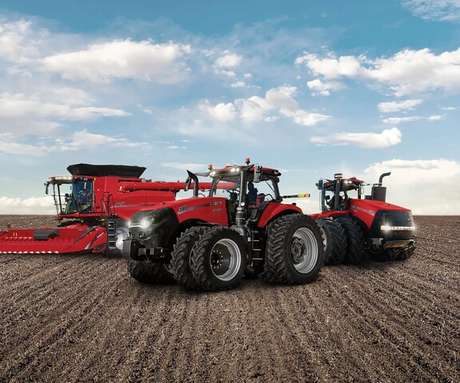 A lineup of Case IH agricultural equipment, including an Axial-Flow combine, a Magnum tractor, and a Steiger tractor, on a farm field.