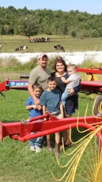 Family standing next to New Holland Hay Rake.