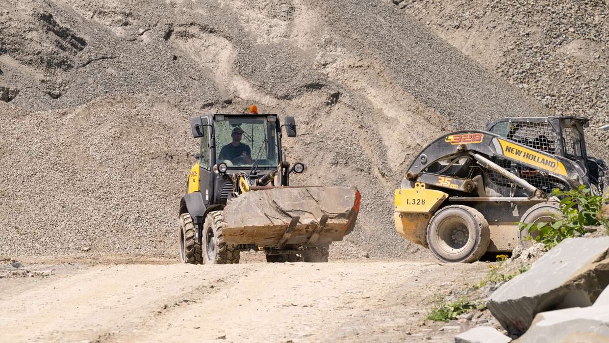 Compact wheel loader and skid steer loader lifting rocks.