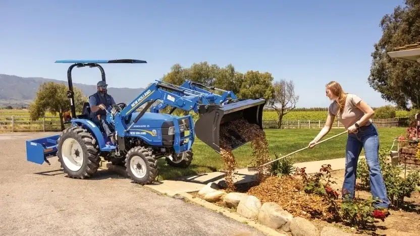 New Holland tractor with a bucket and scraper attachment