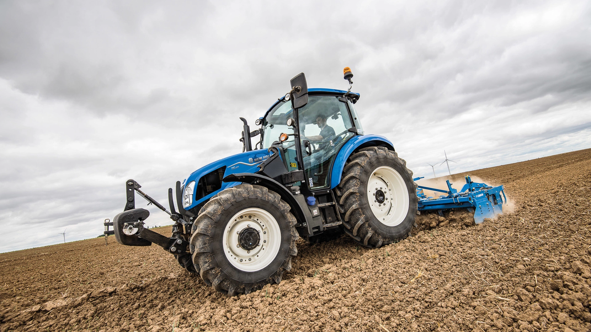 New Holland T5 Utility tractor actively engaged in field work