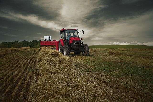 Farmall 95a and SB541 baler in field with dark sky