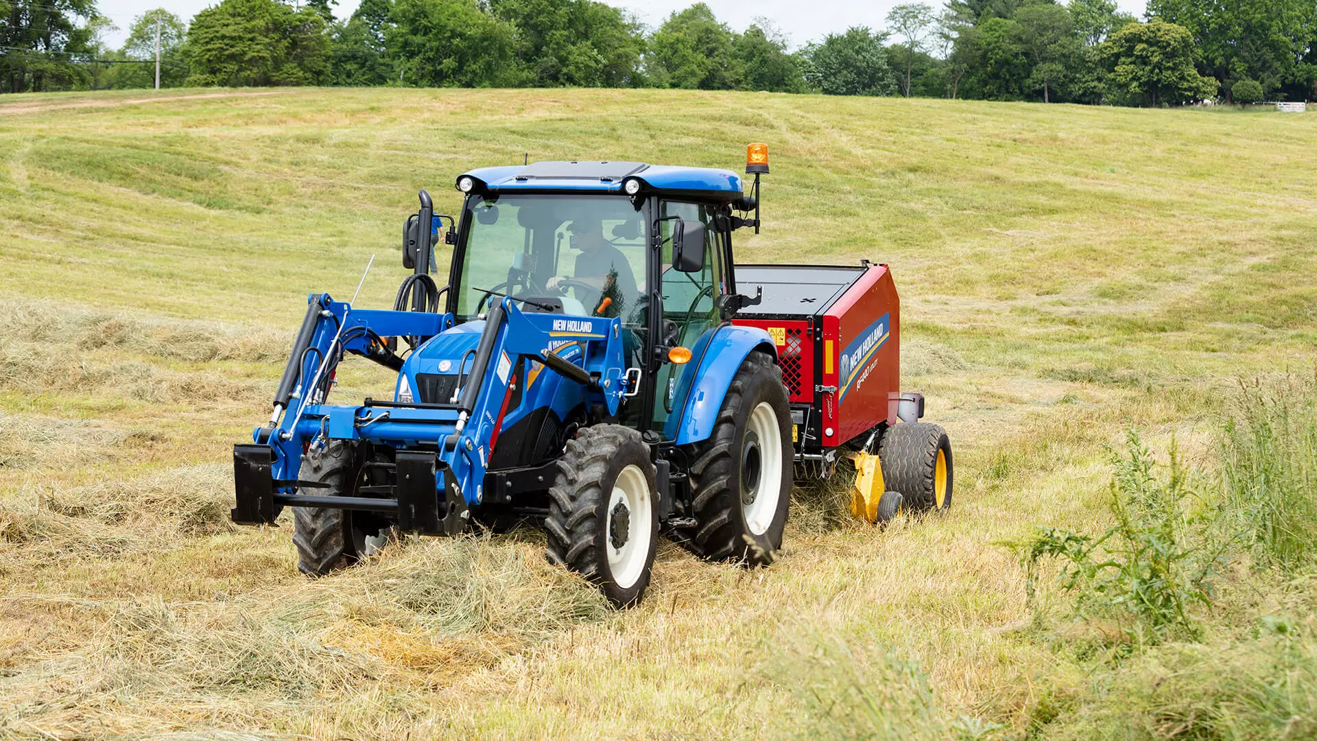 WORKMASTER tractor pulls a baler in the field