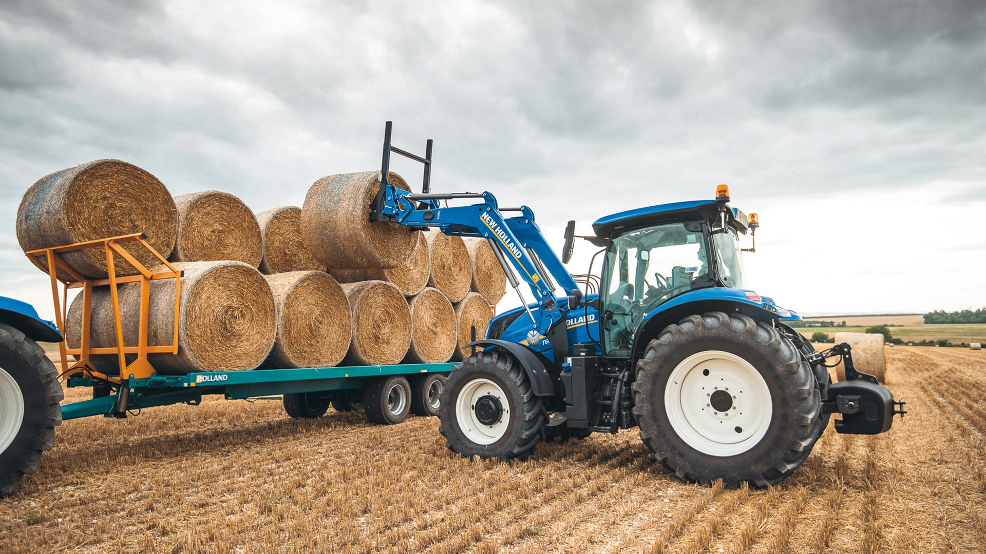 New Holland T5 Dynamic Command & Auto Command tractor in motion, transporting bales