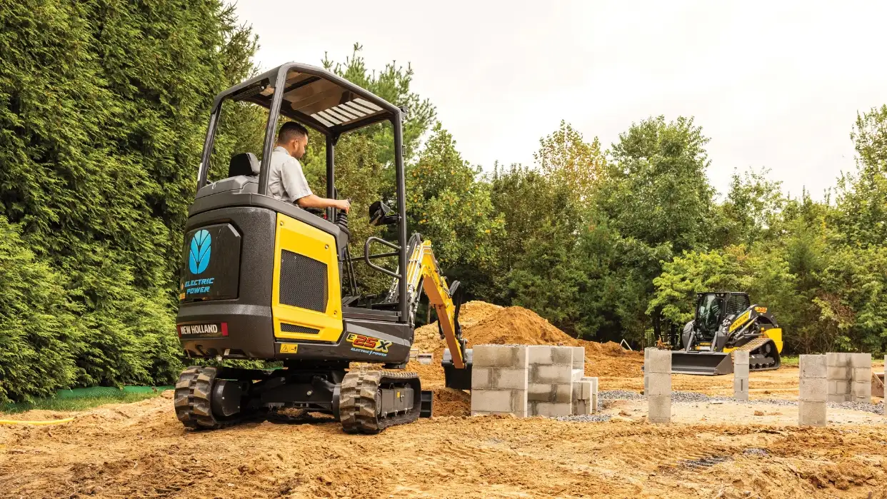 Mini excavator lifting dirt.