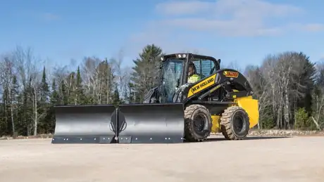 New Holland Skid Steer loader with V plow attached.