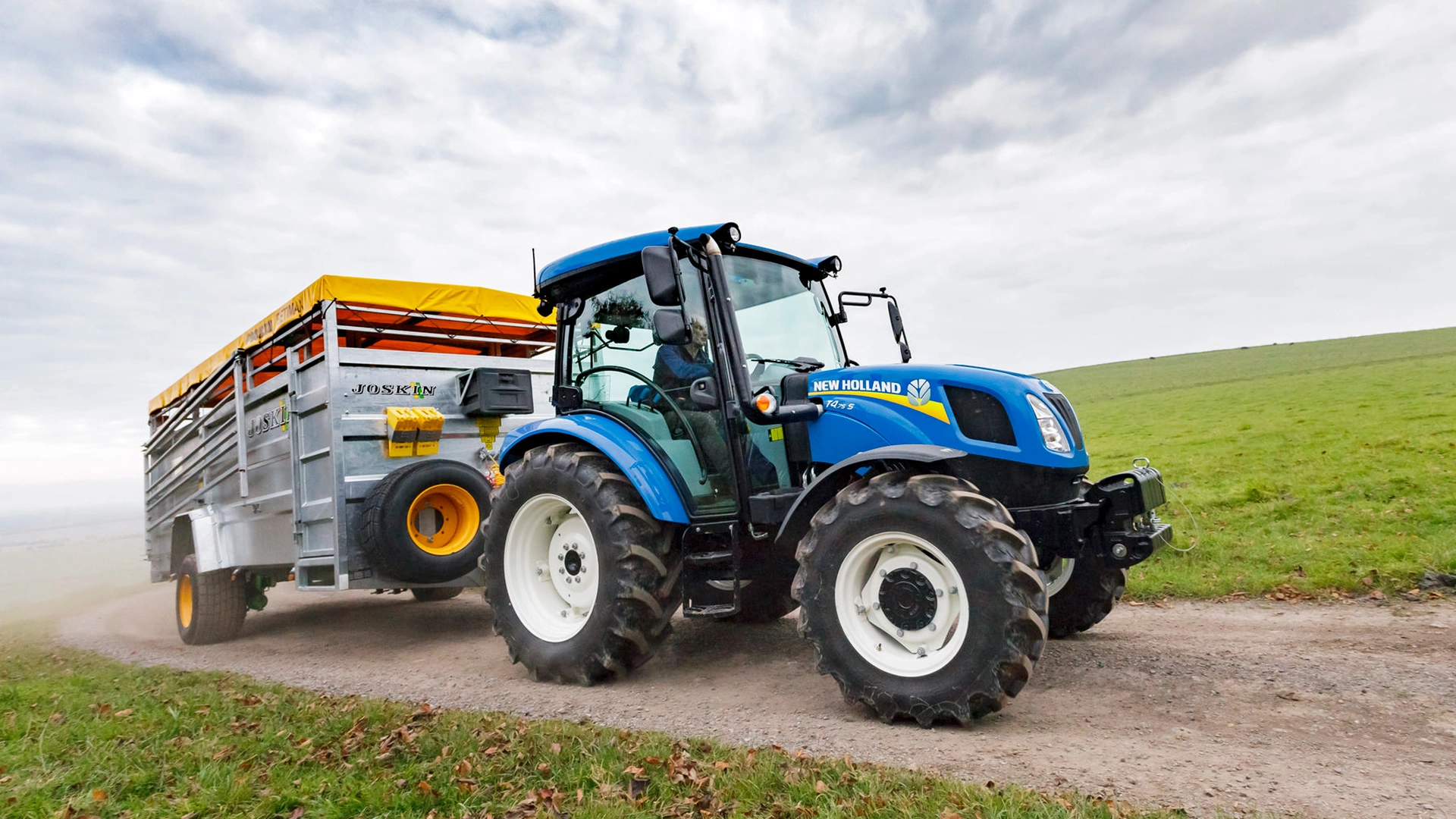 Farming tractor New Holland T4S in action on an agricultural field