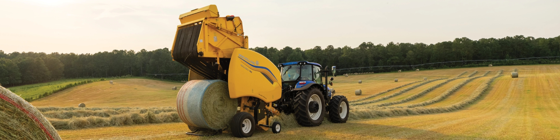 Tractor baling hay in a field.