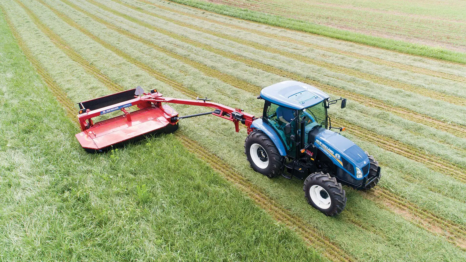 Tractor pulls a Discbine® Side-Pull Disc Mower-Conditioner in the field