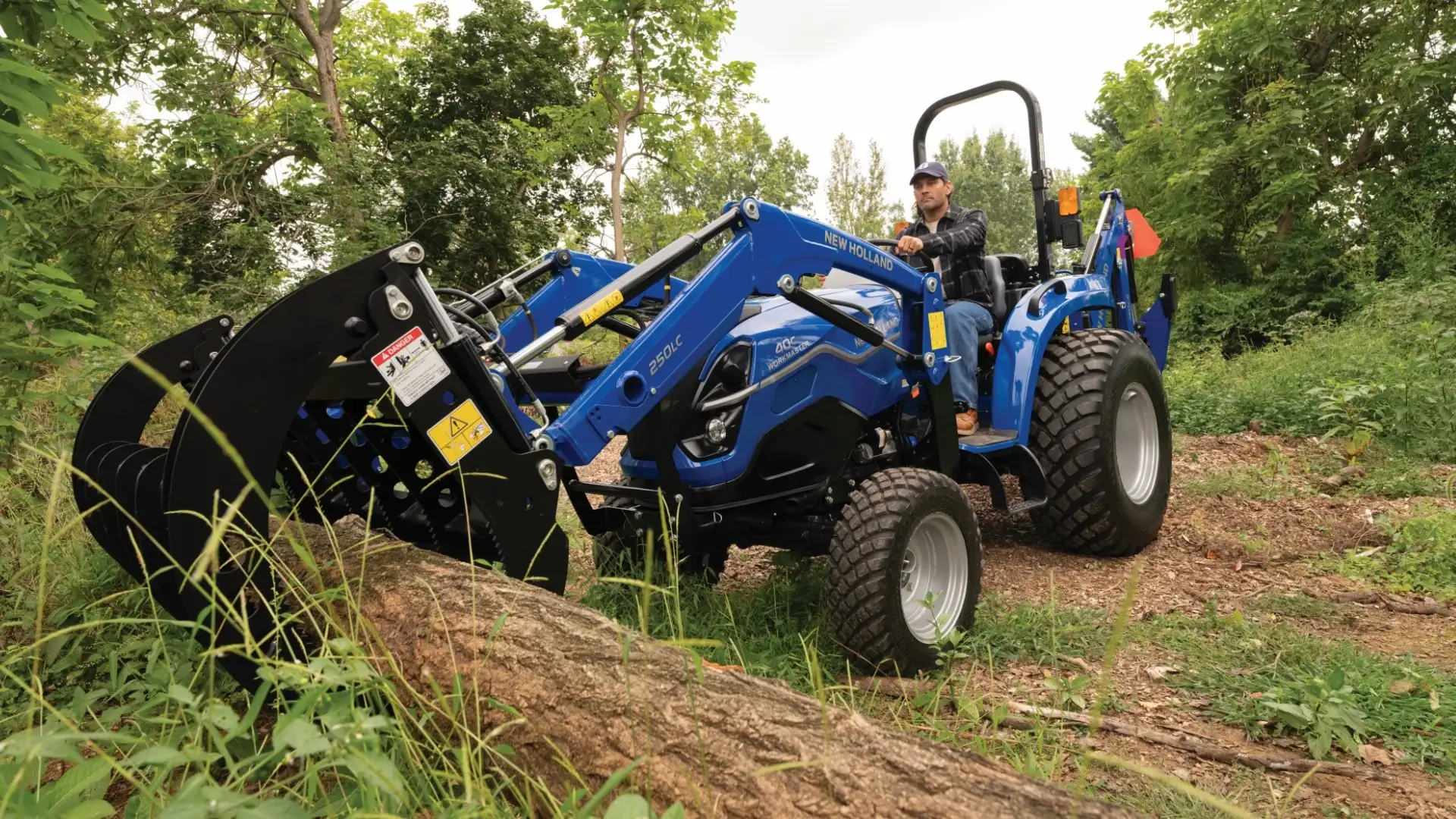 Tractor grabbing wooden log.