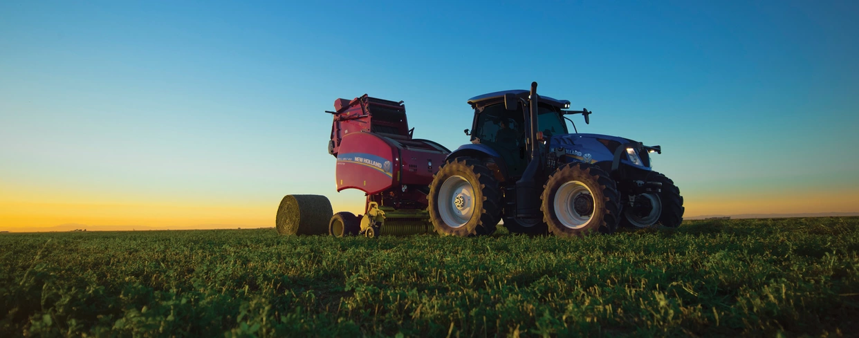 T6 tractor pulling a baler