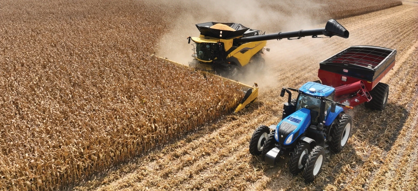 New Holland CR Series combine in the field next to a tractor