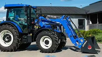 New Holland tractor with 520TL front loader at a contemporary farm setting.