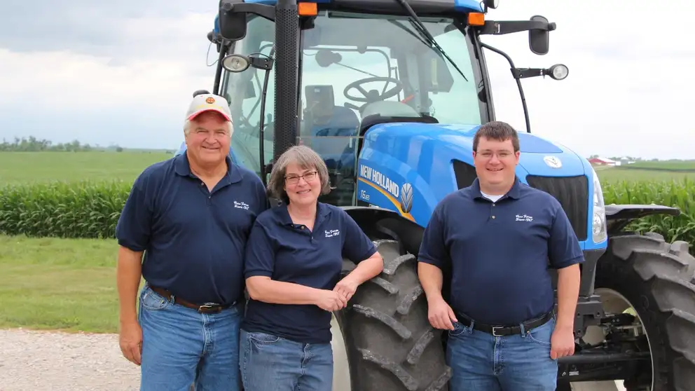 Voss family in front of a New Holland tractor