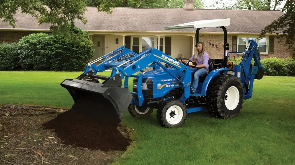 WORKMASTER 25 tractor with loader dumping dirt