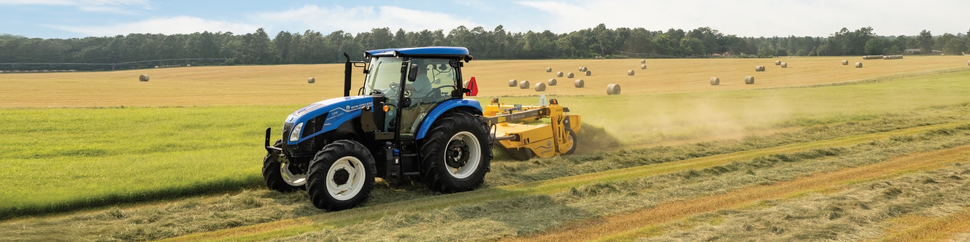 Blue tractor mowing hay.