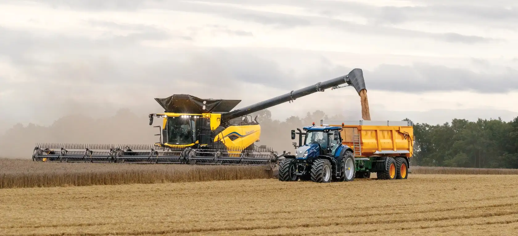 Combine and Tractor harvesting in a field.