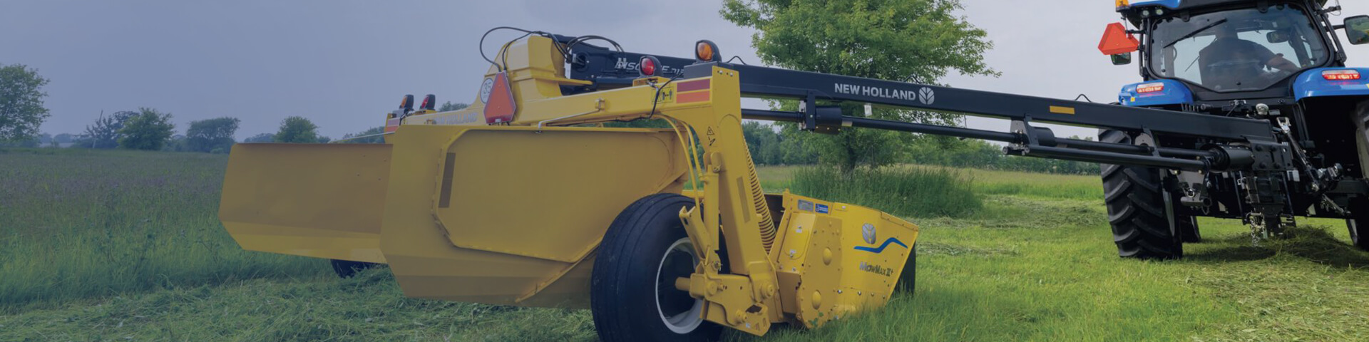 Discbine PlusCenter-Pivot working in field with New Holland tractor