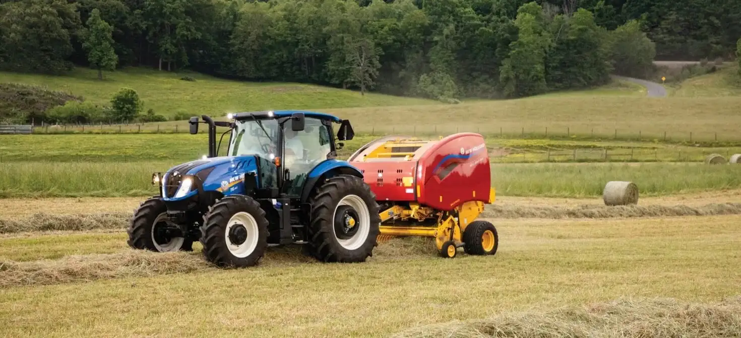 Tractor pulls a Roll-Belt™ Round Baler