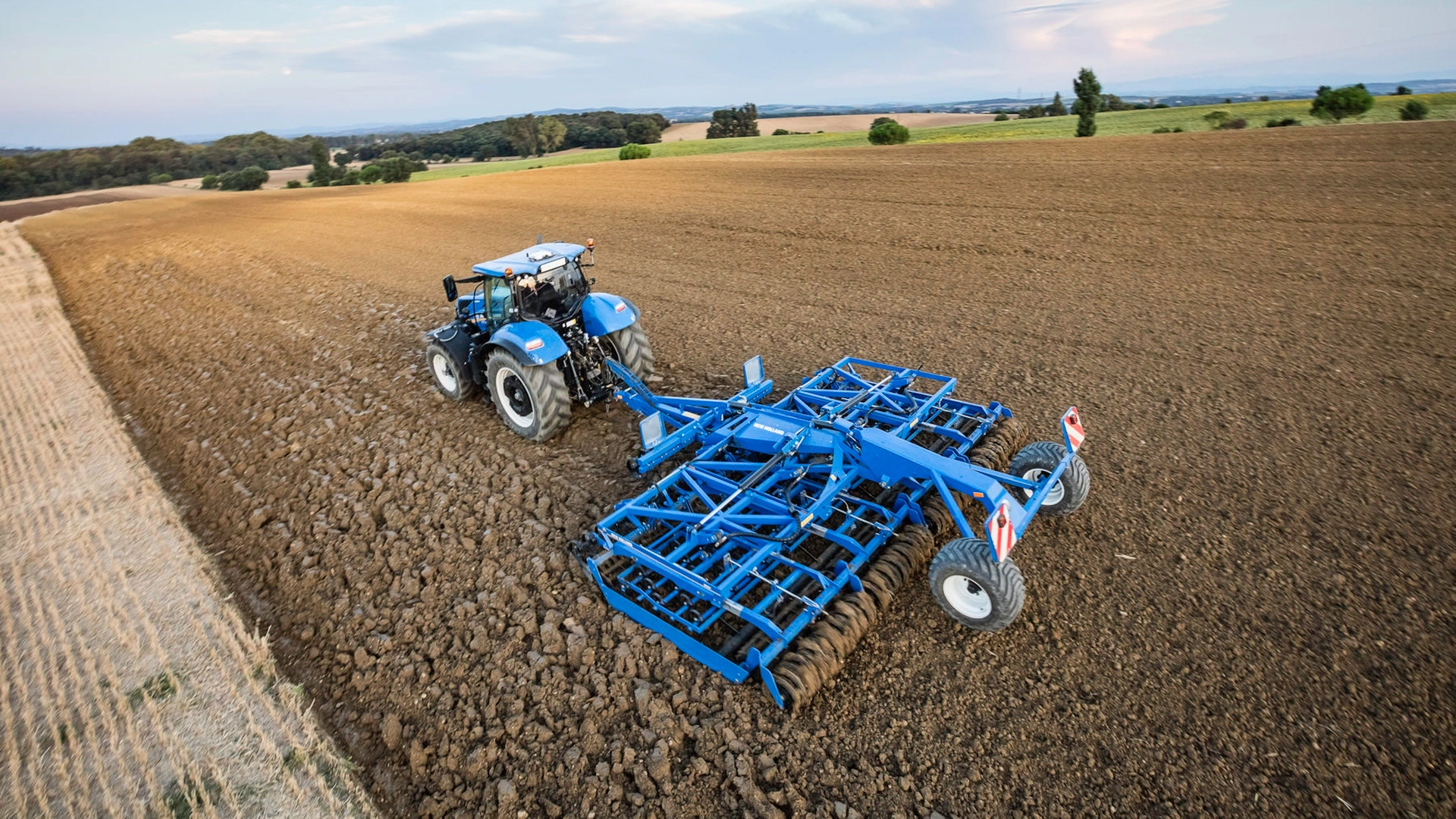 T7 LWB Tractor working on the agricultural field with tillage equipment
