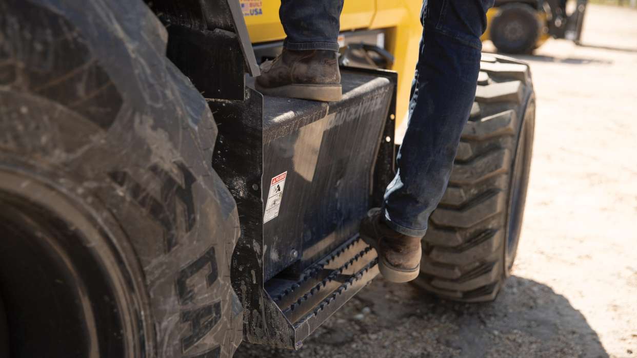 Person stepping off of construction construction equipment.