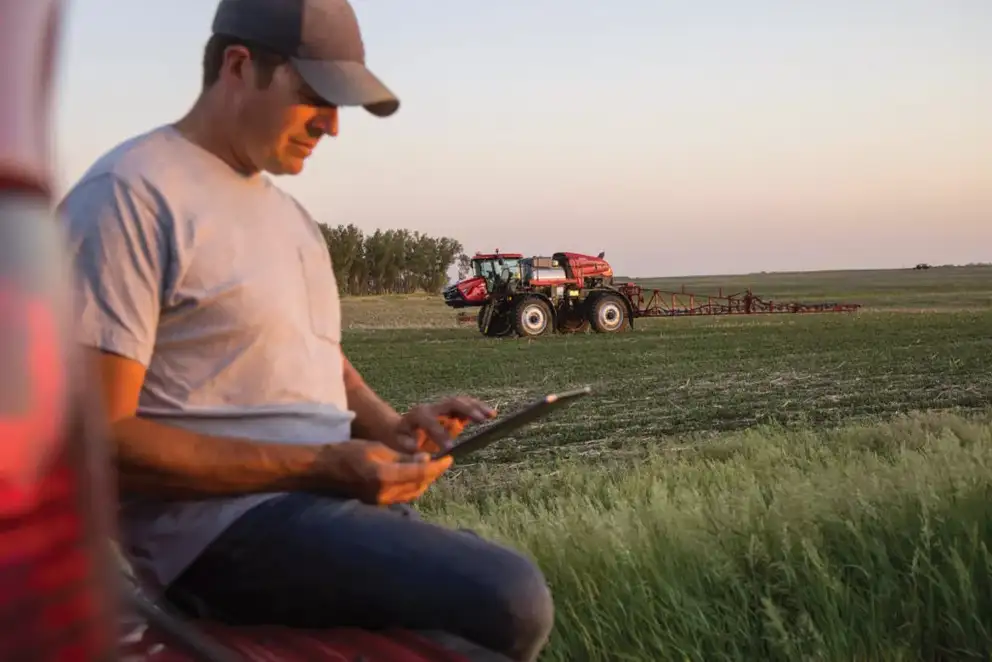 Producer with Ipad in field with Patriot Sprayer