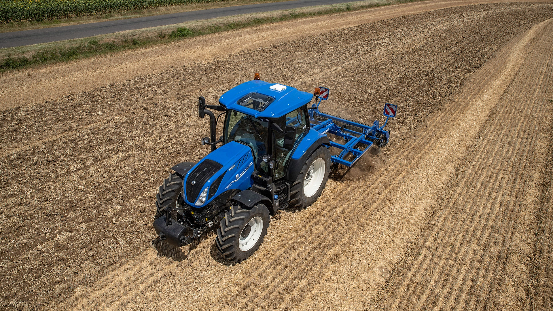 New Holland T5 Dynamic Command & Auto Command tractor actively engaged in agricultural field work