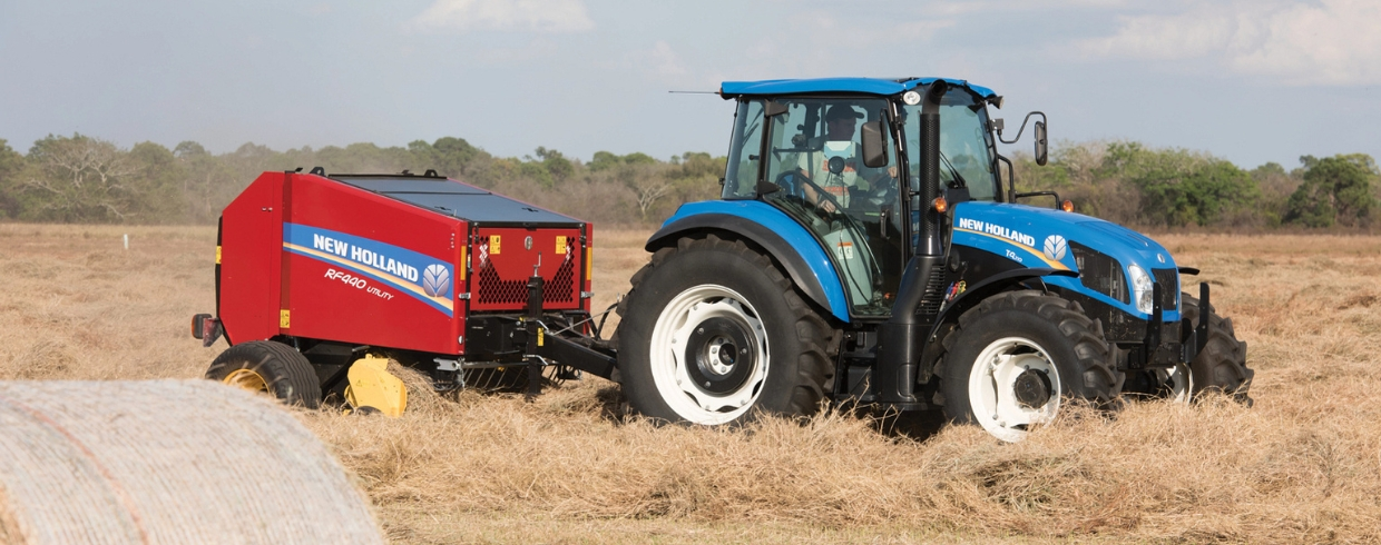 Tractor pulls an RF Fixed Round Baler in the field