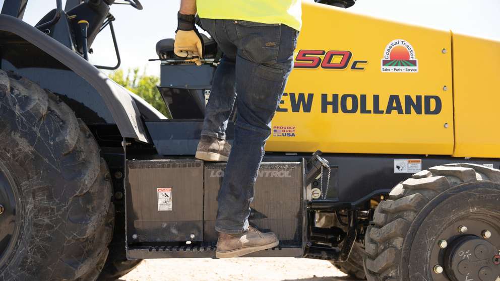 Man stepping onto compact wheel loader.