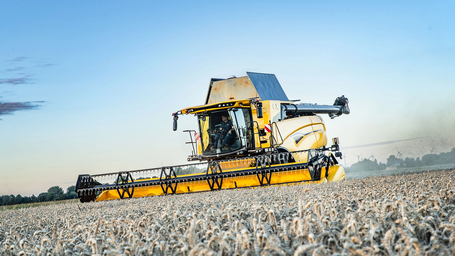 Agricultural scene showcasing New Holland's CX7 & CX8 combines using headers