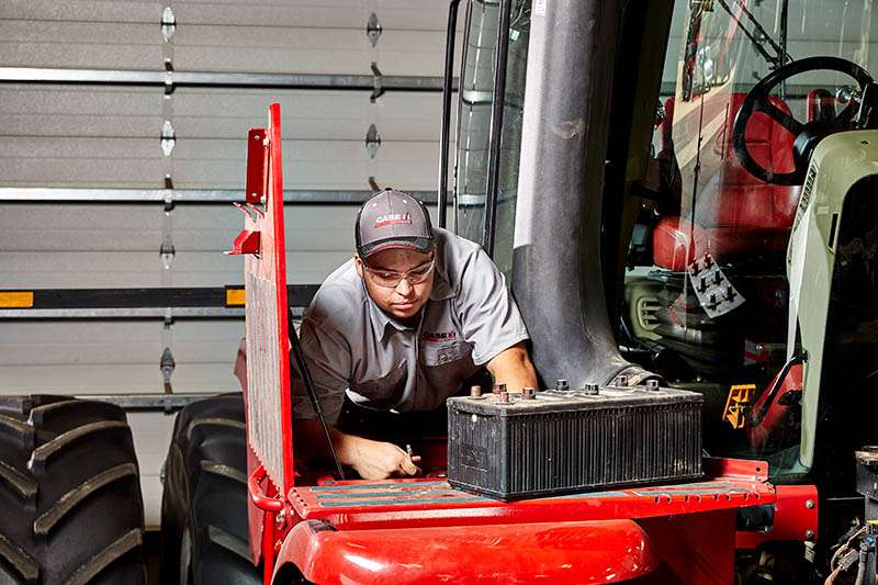 Case IH Technician servicing battery