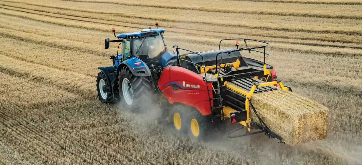 Tractor pulls a BigBaler PLUS Large Square Baler in the field
