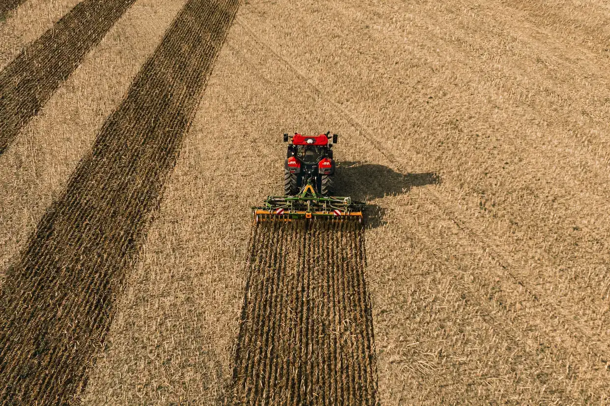 Red Case IH Puma next generation tractor sitting in field with implement attached