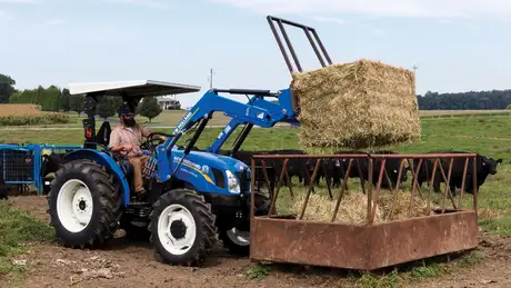 WORKMASTER™ Utility 50 – 70 Series tractor lifts a bale