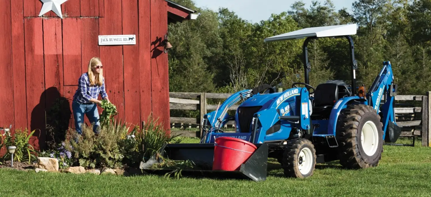 Woman works in the garden next to her WORKMASTER compact tractor