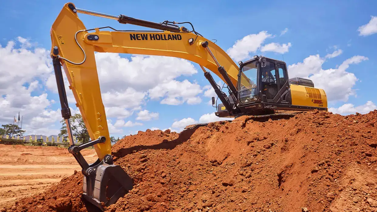 Escavadeira hidráulica da New Holland Construction sobre um monte de terra. 
