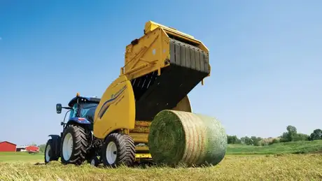 Round Baler compressing bale of hay.