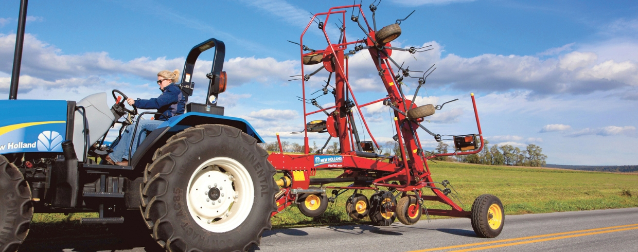 ProTed™ rotary tedder pulled behind a New Holland tractor