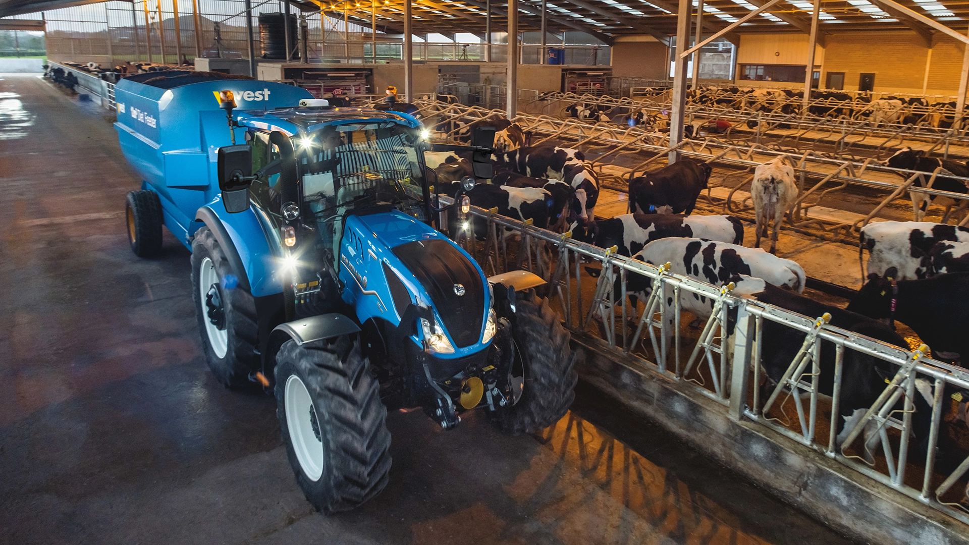 New Holland T5 Electro Command tractor transporting goods across the cow farm