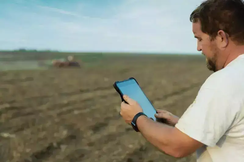 producer with ipad in brown field