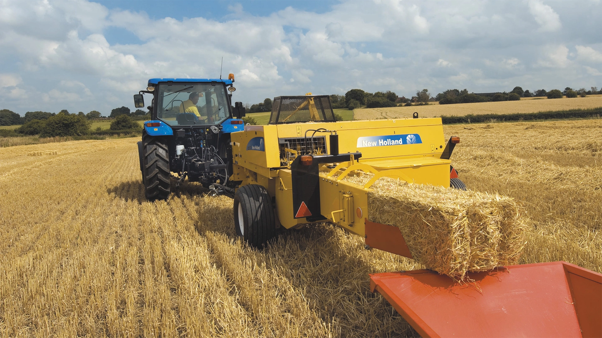New Holland tractor with a BC5000 baler, producing a square bale.