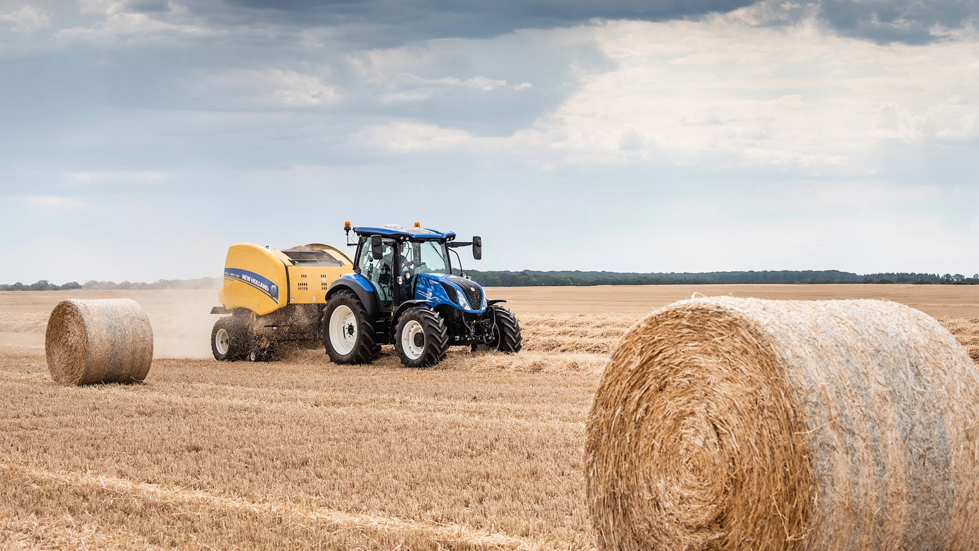 T5 DYNAMIC COMMAND™ ＆ AUTO COMMAND™ tractor with a baler on an agricultural field
