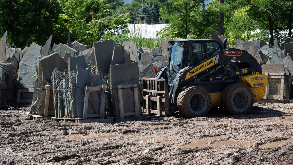 Skid Steer Loader lifting rocks.