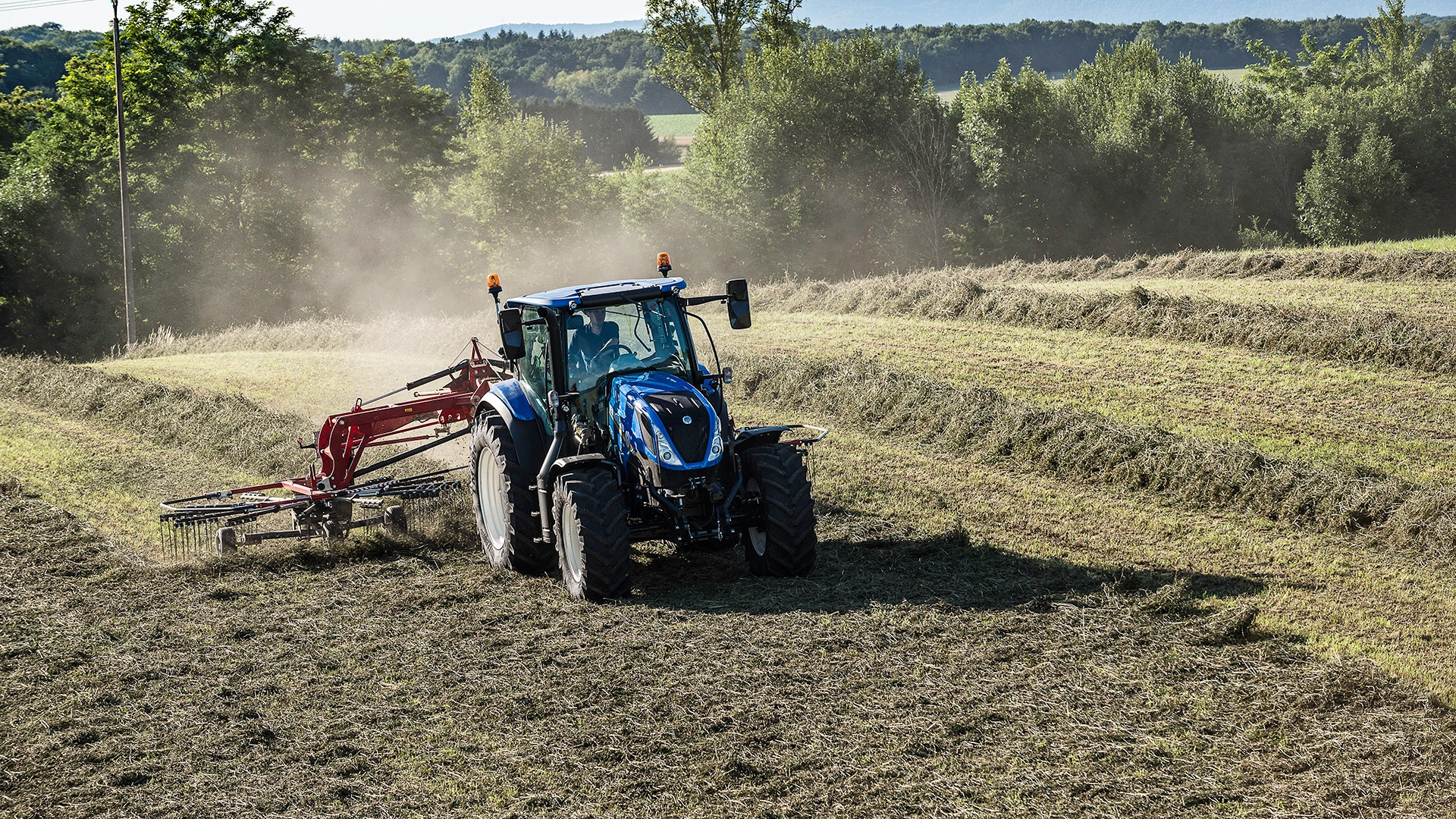 New Holland T5 Dynamic Command & Auto Command tractor with a rake working on the field