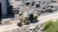 Compact wheel loader lifting rocks.