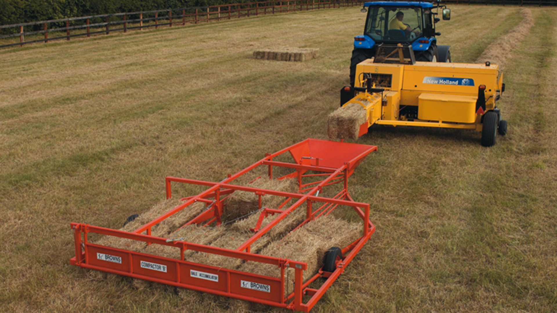 New Holland tractor towing a BC5000 baler, with a bale accumulator collecting square hay bales in the foreground.