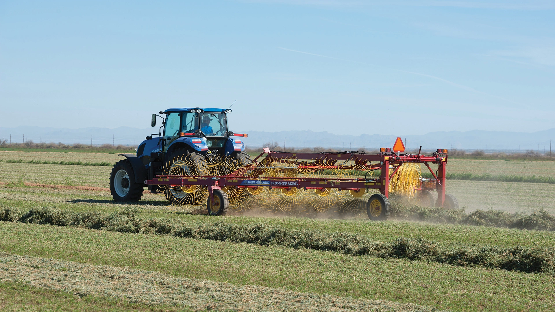 TS6 Series II tractor pulls a hay rake