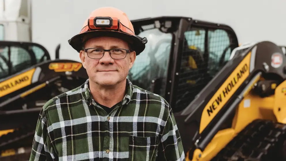 Man standing in front of compact track loader.