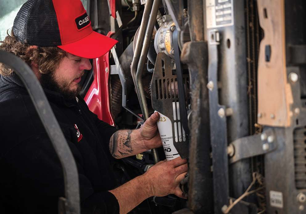 Case IH worker working on tractor with underparts imaged