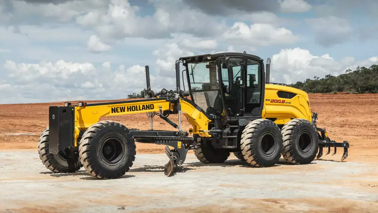 foto ao ar livre, da motoniveladora New Holland Construction parada, destacando sua lateral